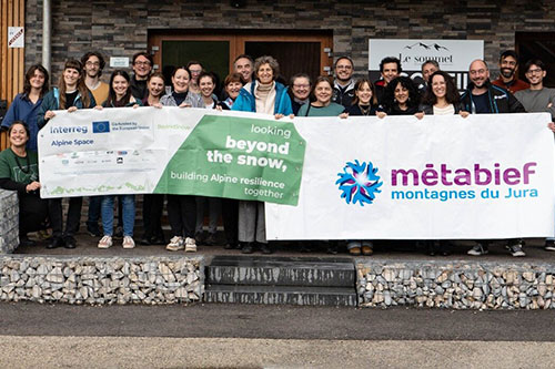 A group of project partners posing in front of the BeyondSnow poster